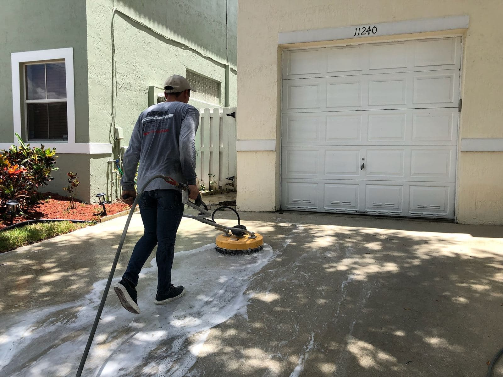 Crew using a surface cleaner on a driveway — Finesse Cleaning, South Florida