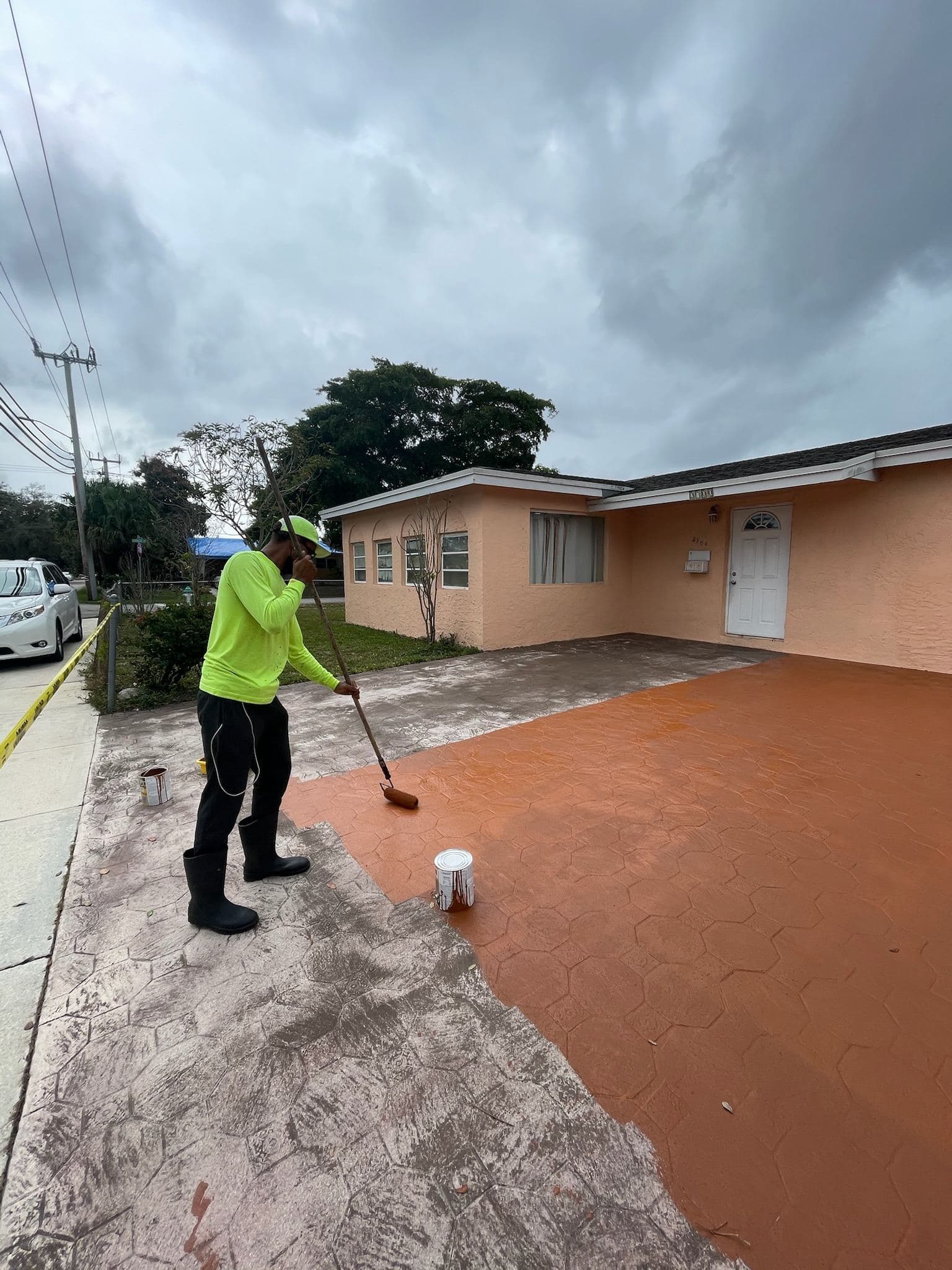 Applying fresh coating to a driveway — Finesse Cleaning, South Florida